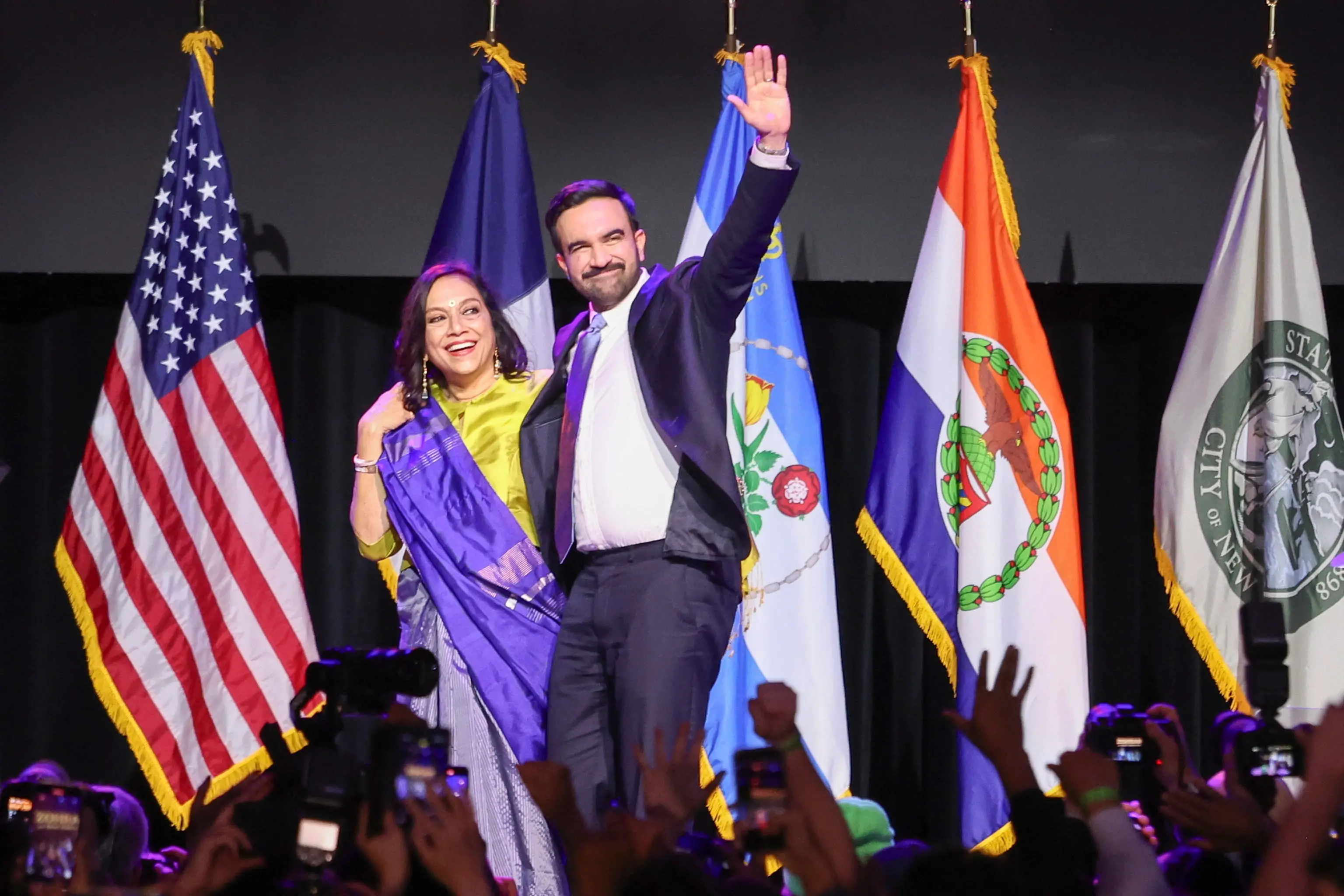 epa12504034 Mayor-elect of New York City Zohran Mamdani (R) and his mother Mira Nair (L) wave to the crowd during an election night party hosted by the Democratic nominee in the Brooklyn borough of New York, USA, 04 November 2025. Mamdani has defeated Andrew Cuomo to win the New York mayoral election. EPA/SARAH YENESEL