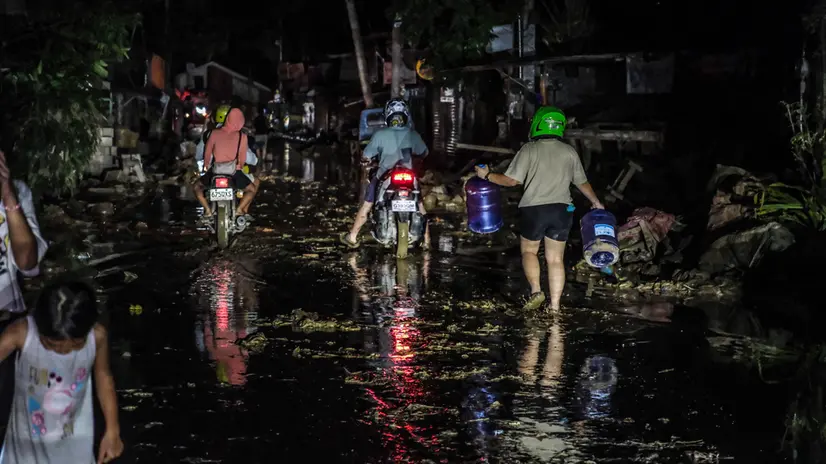 epa12507894 People ride motorcycles and walk in mud from flood caused by typhoon Kalmaegi at a residential district in Liloan municipality, Cebu province, Philippines, 06 November 2025. The Philippines' Office of Civil Defense stated that 114 have been reported dead following the effects of Typhoon Kalmaegi, which crossed the Visayas region of central Philippines on 04 November. The typhoon brought on floods, power outages, and damage to property before leaving Philippine territory and moving in the general direction of Vietnam. EPA/JUANITO ESPINOSA