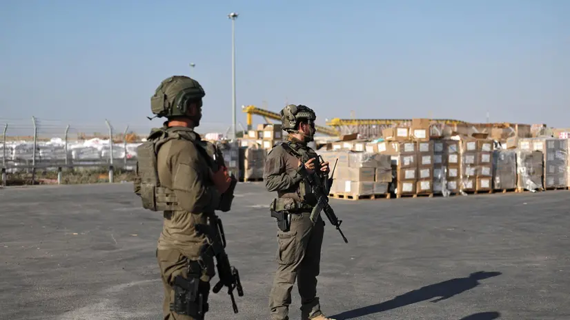 epa12275613 A photo taken while embedded with the Israeli Army shows Israeli soldiers standing guard near humanitarian aid on the Palestinian side of the Kerem Shalom border crossing, between the Gaza Strip and Israel, 31 July 2025 EPA/ATEF SAFADI