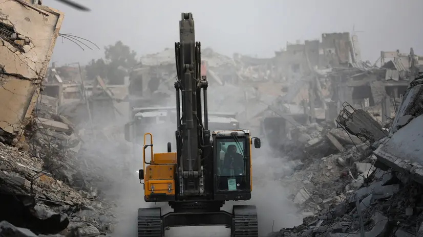 epa12505681 Red Cross workers assist as fighters of the Al-Qassam Brigades, the military wing of the Hamas movement, search for the bodies of Israeli hostages in Al Shejaeiya neighbourhood in the east of the Gaza City, Gaza Strip, 05 November 2025. EPA/MOHAMMED SABER