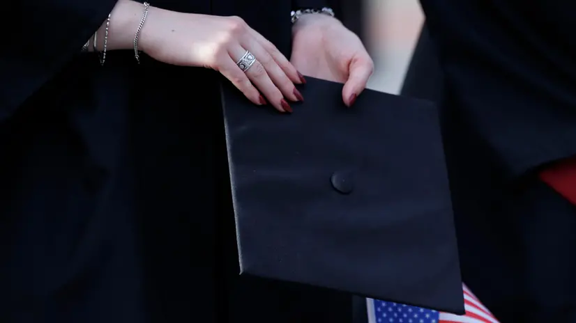 epa12139599 A graduating Harvard student holds her mortar board during a rally in support of the international student population at Harvard and other US Universities, outside the Science Center on the Harvard University campus in Cambridge, Massachusetts, USA, 27 May 2025. On 23 May 2025, a federal judge blocked the US President Trump administration's attempt to revoke Harvard's ability to enroll international students with a temporary restraining order. EPA/CJ GUNTHER