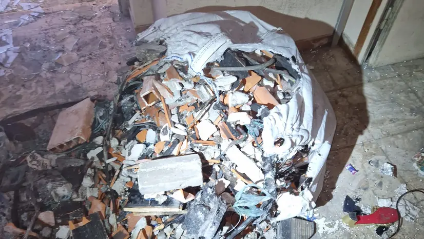 I cumuli di macerie nell'androne condominiale - © www.giornaledibrescia.it