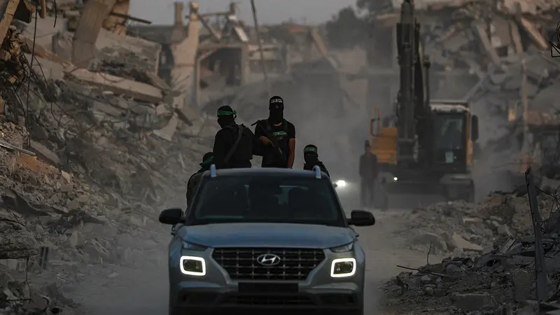 epa12505556 Fighters of the Al-Qassam Brigades, the military wing of the Hamas movement, stand guard as they search for the bodies of Israeli hostages alongside Red Cross workers in Al Shejaeiya neighbourhood in the east of the Gaza City, Gaza Strip, 05 November 2025. EPA/MOHAMMED SABER