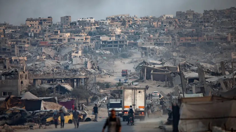 epaselect epa12512519 Displaced Palestinians walk among heavily damaged buildings in Khan Yunis refugee camp, southern Gaza Strip, 08 November 2025. Around 1.9 million people in Gaza, nearly 90 percent of the population, have been displaced since the Israel-Hamas conflict began in October 2023, according to the UN. EPA/HAITHAM IMAD
