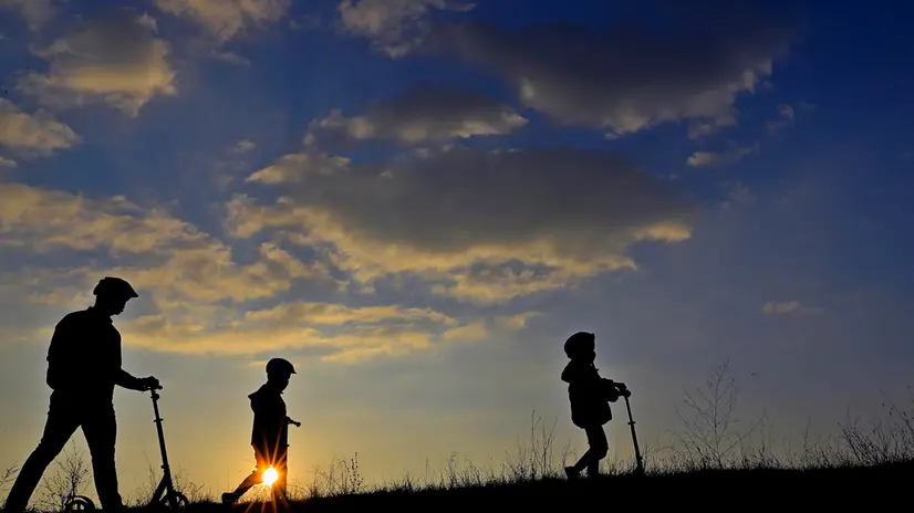 epa08823036 A father and his sons, as seen against the sun, walk at sunset on the side dam of Vacaresti wild park, in Bucharest, Romania, 15 November 2020. EPA/ROBERT GHEMENT