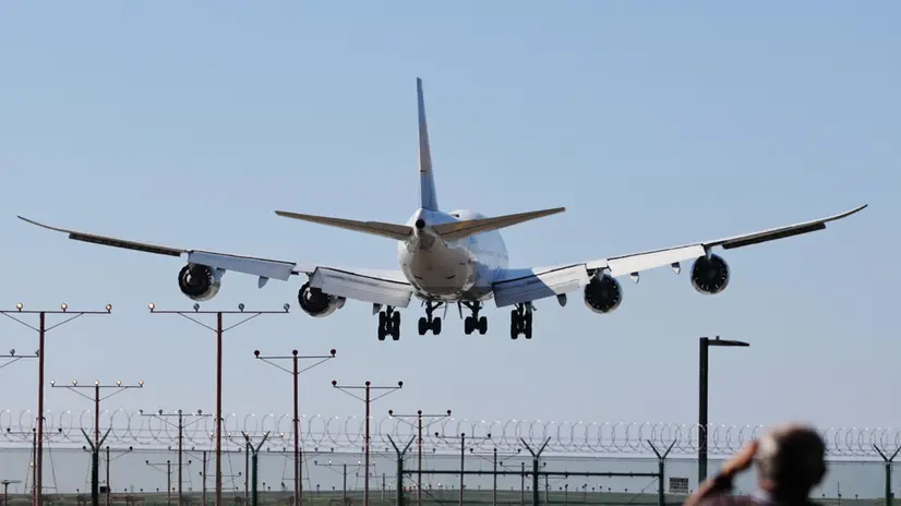 epa12511501 A person watches as an airplane descends for landing at Los Angeles International Airport (LAX) in Los Angeles, California, USA, 07 November 2025. US airlines started canceling hundreds of flights on 07 November 2025, hours after the Federal Aviation Administration (FAA) ordered the cuts amid the current US government shutdown. EPA/ALLISON DINNER
