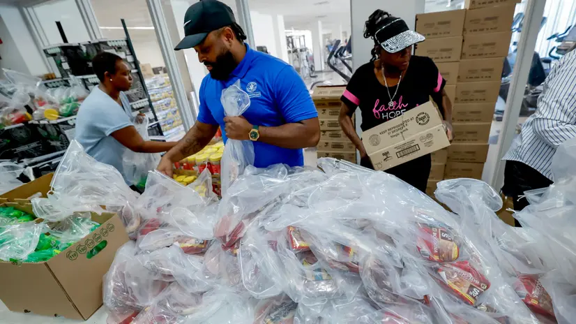 epa12509621 Volunteers help assemble food aid bags during a free food distribution at the Young Family YMCA in Atlanta, Georgia, USA, 06 November 2025. The longest US federal government shutdown has resulted in a loss of benefits for SNAP recipients and unpaid federal workers. The YMCAÕs weekly neighborhood food distribution gave out about 4,355 kilos to about 400 families. EPA/ERIK S. LESSER