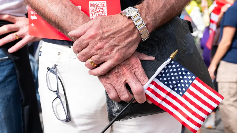 epa12463024 A man holds a small American flag on Pennsylvania Avenue during the 'No Kings' protest in Washington, DC, USA, 18 October 2025. The protest is part of a nationwide 'No Kings' day of action, opposing what organizers see as authoritarian overreach and threats to democracy under US President Trump. EPA/LUKE JOHNSON