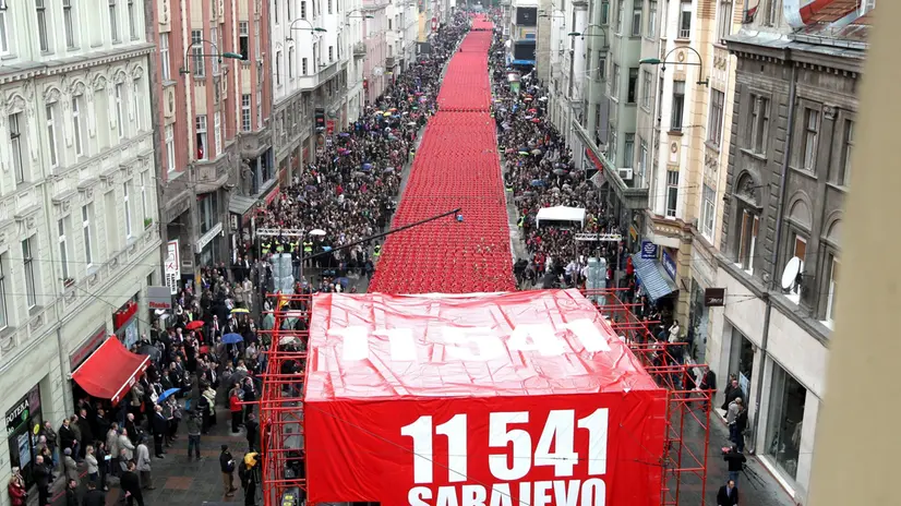 epa03173428 An aerial view photo shows a long line of 11,541 red chairs in the main street of Sarajevo, Bosnia, 06 April 2012. One for each victim, 11,541 empty red chairs were set up in the Bosnian capital Sarajevo for the 20th anniversary of the siege of Sarajevo and the start of the Bosnian war in 1992. EPA/FEHIM DEMIR