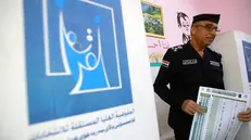 epa12513595 An Iraqi policeman holds a ballot paper during the early voting for the parliamentary elections at a polling station in Baghdad, Iraq, 09 November 2025. Members of the security forces and the military are casting their ballots in early voting for the Iraqi parliamentary elections before the general vote on 11 November. EPA/CEERWAN AZIZ
