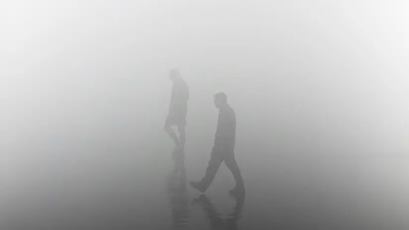 Due persone passeggiano nella nebbia