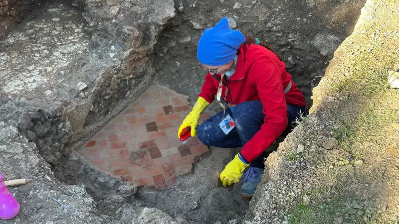 Un'archeologa a lavoro sul fondo in cocciopesto del porticato - © www.giornaledibrescia.it