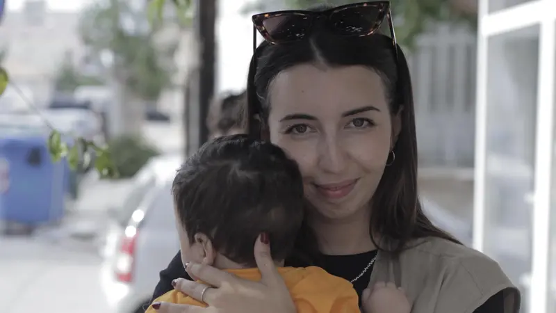 Una volontaria del progetto Corinto con un piccolo ospite