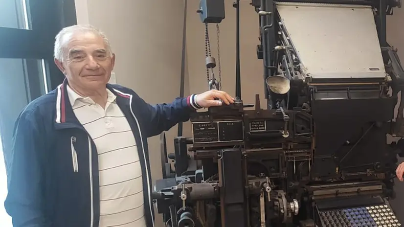 Giovanni Bartolomini e la linotype esposta nella Sala Libretti del Giornale di Brescia