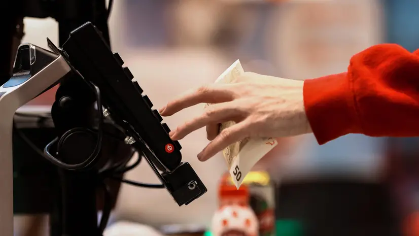 Un commesso con una banconota da 50 euro in un supermercato a Sofia - Foto Ansa © www.giornaledibrescia.it