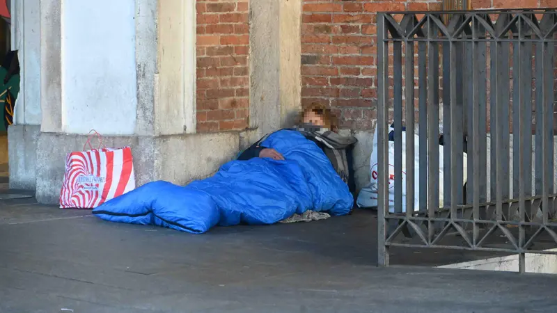 Una persona senza fissa dimora fuori dalla stazione di Brescia - Foto Marco Ortogni/Neg © www.giornaledibrescia.it