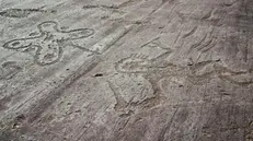 Incisioni rupestri in Valcamonica, a sinistra la rosa camuna