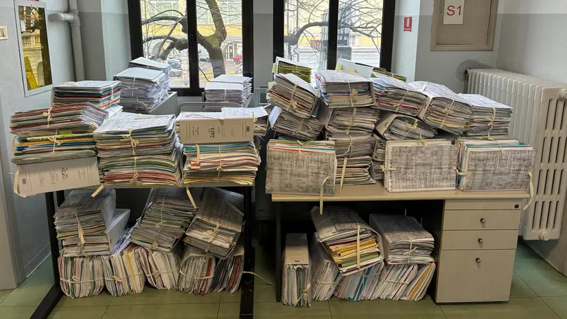 Faldoni di documenti negli uffici del Giudice di pace - © www.giornaledibrescia.it