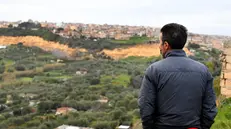 Un residente osserva Niscemi da lontano - Foto Ansa © www.giornaledibrescia.it