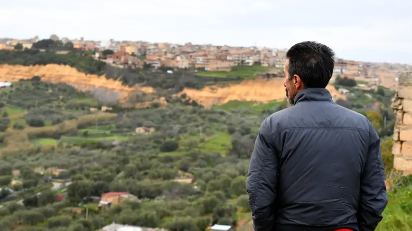 Un residente osserva Niscemi da lontano - Foto Ansa © www.giornaledibrescia.it