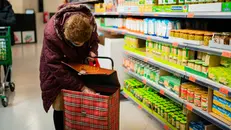 Una signora fa la spesa al supermercato