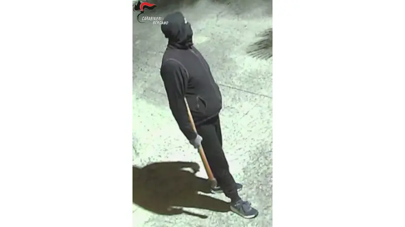 Uno dei rapinatori con l'ascia in mano - © www.giornaledibrescia.it
