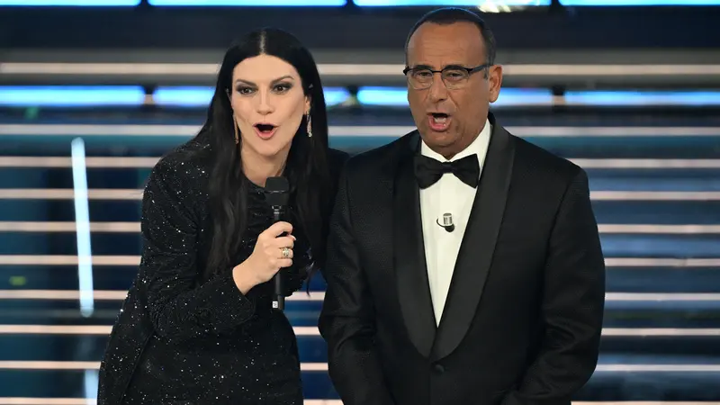 Sanremo Festival host and artistic director Carlo Conti (R) with Italian singer Laura Pausini on stage at the Ariston theatre during the 76th edition of the Sanremo Italian Song Festival, in Sanremo, Italy, 25 February 2026. The music festival will run from 24 to 28 February 2026. ANSA/RICCARDO ANTIMIANI