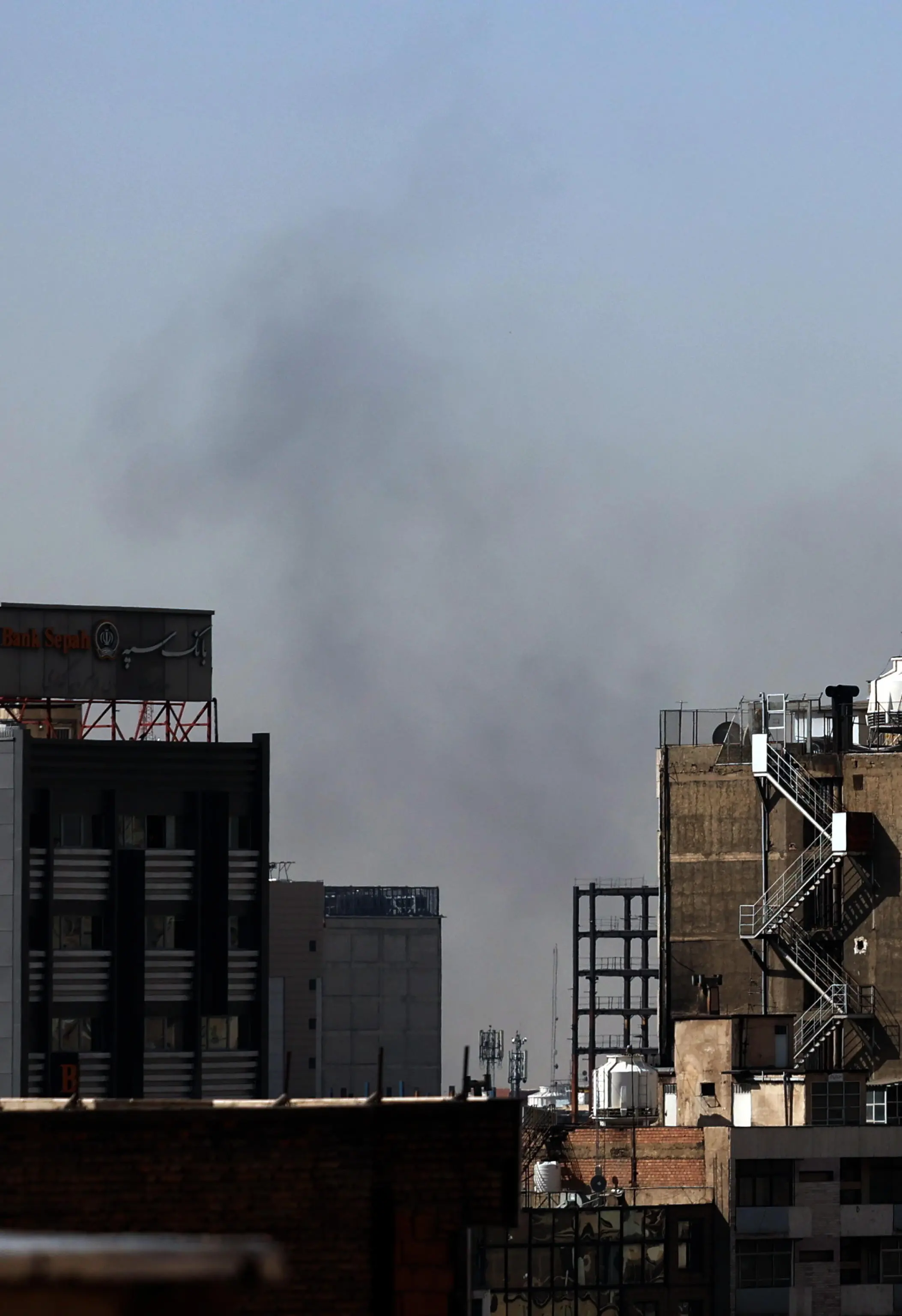Colonne di fumo si alzano tra i palazzi di Teheran