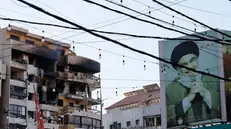 Un cartellone con una foto del defunto leader di Hezbollah Hassan Nasrallah vicino a un edificio danneggiato a Beirut - Foto Epa  © www.giornaledibrescia.it