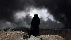 Una donna osserva l'effetto dei bombardamenti su Teheran - Foto Ansa/Epa/Abedin Taherkenareh © www.giornaledibrescia.it