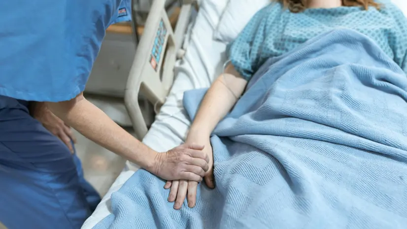 Un'infermiera conforta una paziente