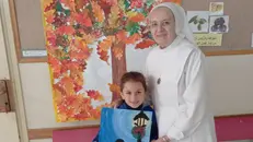 Suor Ginetta con un'alunna della scuola che ha realizzato un disegno per la figlia di un donatore