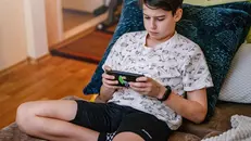 Un adolescente alle prese con uno smartphone