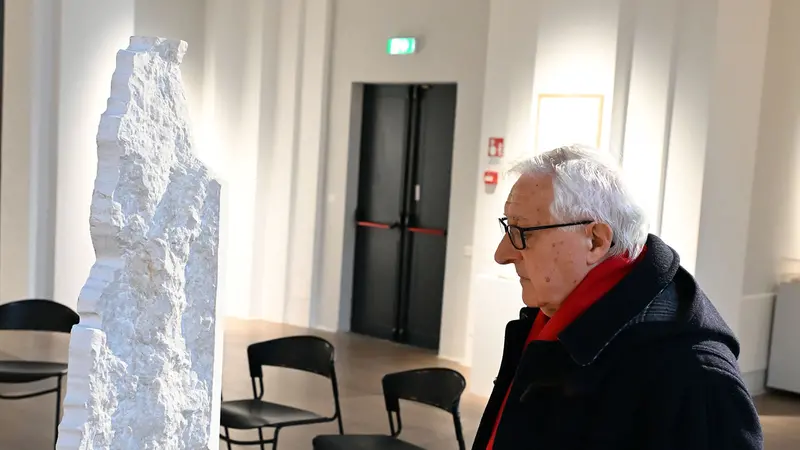 Manlio Milani davanti al calco negativo ella colonna sbrecciata dalla bomba del 28 maggio