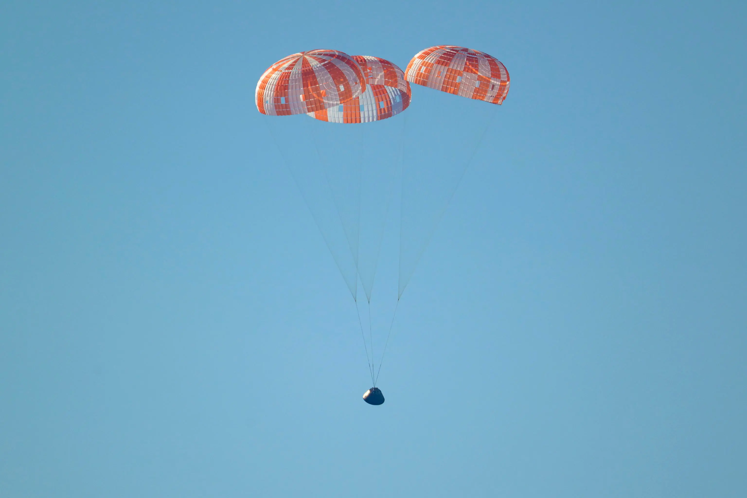 epa12881912 A handout photo made available by the National Aeronautics and Space Administration (NASA) shows NASA's Orion spacecraft 'Integrity' as it descends by parachute in the Pacific Ocean, 10 April 2026. The mission, crewed by NASA astronauts Reid Wiseman, commander, Victor Glover, pilot, Christina Koch, mission specialist, and CSA (Canadian Space Agency) astronaut Jeremy Hansen, mission specialist, completed a flyby of the Moon and returned to Earth. EPA/BILL INGALLS / NASA HANDOUT HANDOUT EDITORIAL USE ONLY/NO SALES