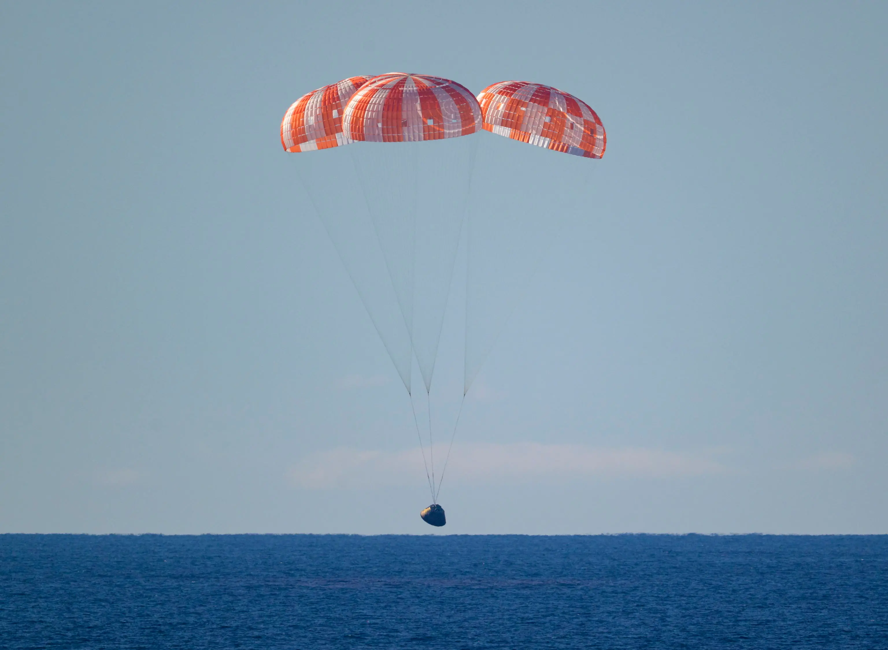 epa12881908 A handout photo made available by the National Aeronautics and Space Administration (NASA) shows NASA's Orion spacecraft 'Integrity' as it descends by parachute in the Pacific Ocean, 10 April 2026. The mission, crewed by NASA astronauts Reid Wiseman, commander, Victor Glover, pilot, Christina Koch, mission specialist, and CSA (Canadian Space Agency) astronaut Jeremy Hansen, mission specialist, completed a flyby of the Moon and returned to Earth. EPA/BILL INGALLS / NASA HANDOUT HANDOUT EDITORIAL USE ONLY/NO SALESHANDOUT EDITORIAL USE ONLY/NO SALES