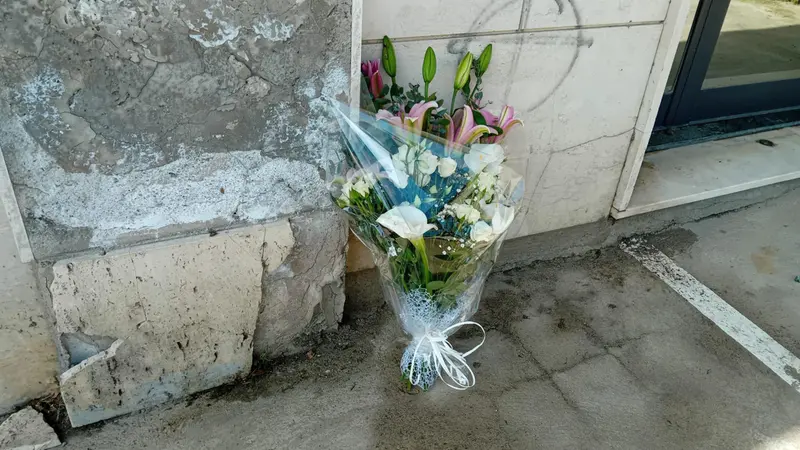 Un mazzo di fiori sul luogo a Catanzaro dove stamani una donna si è gettata dal balcone con i tre figli - Ansa © www.giornaledibrescia.it