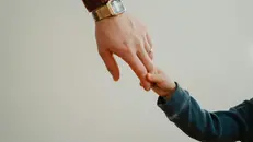 Padre mano per la mano con il figlio (foto simbolica)