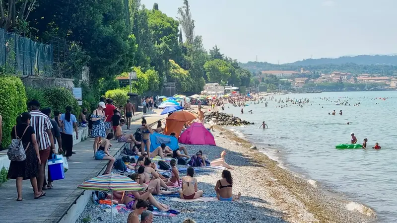 Turisti e residenti affollano una delle spiagge del Basso Garda
