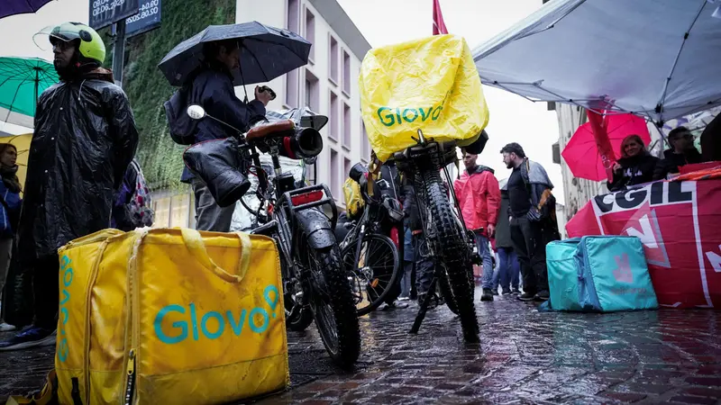 Alcuni rider di Glovo e Deliveroo in piazza