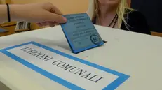 Una scheda di voto per le Comunali viene depositata nell'urna - © www.giornaledibrescia.it
