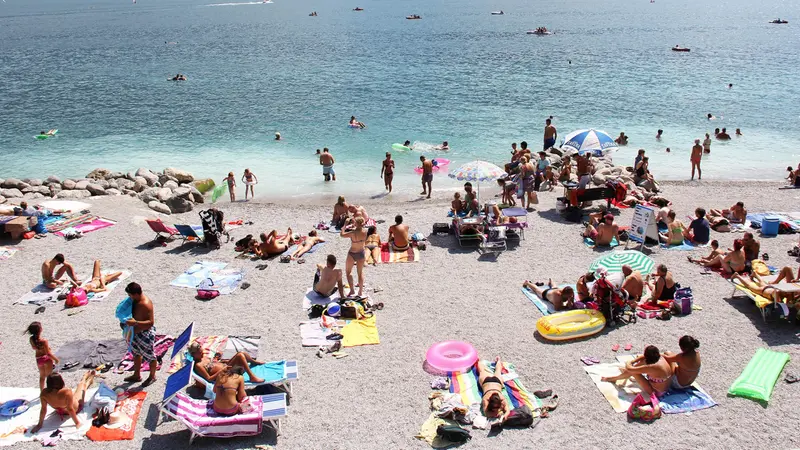 Turisti in spiaggia sul lago di Garda