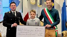 La consegna dell'assegno al sindaco e al comandate della Locale - © www.giornaledibrescia.it