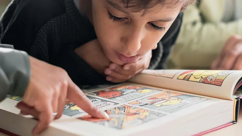 Un bambino impegnato nella lettura