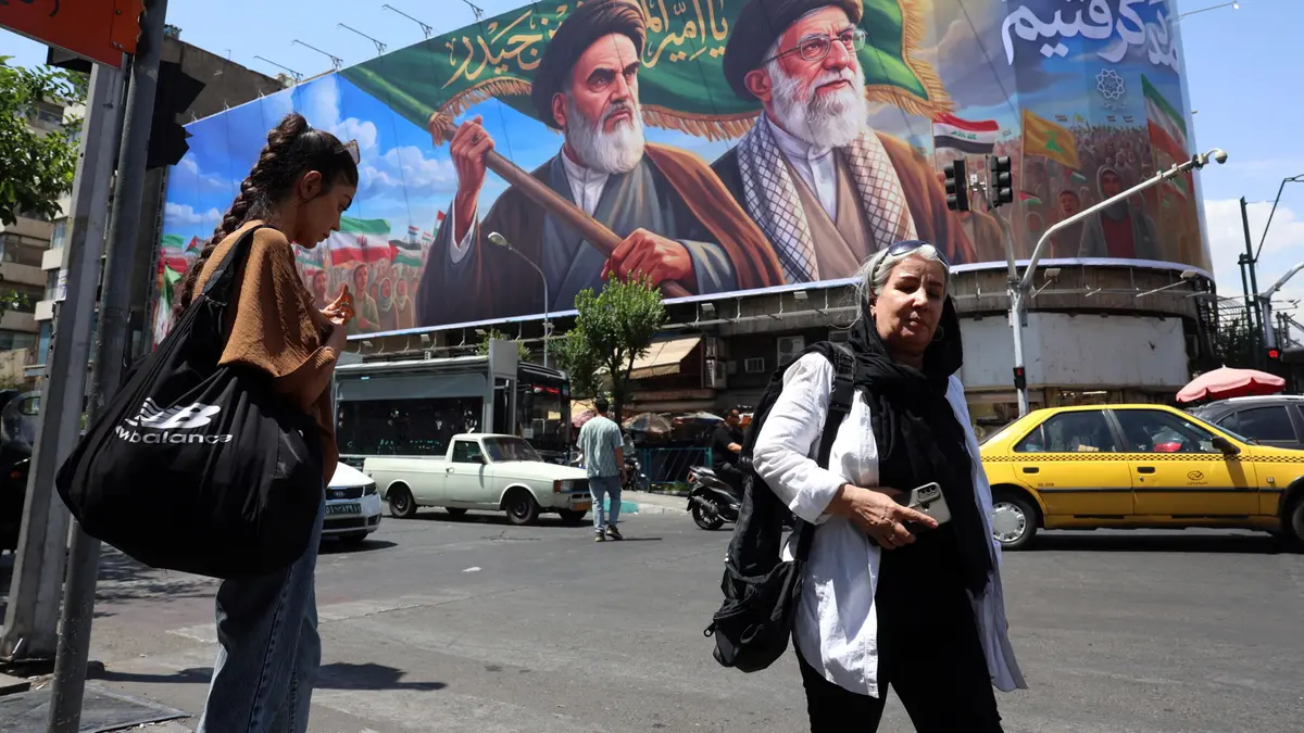 Iraniani davanti a un enorme cartellone pubblicitario raffigurante l'Ayatollah Ruhollah Khomeini l'Ayatollah Ali Khamenei - Foto Ansa © www.giornaledibrescia.it