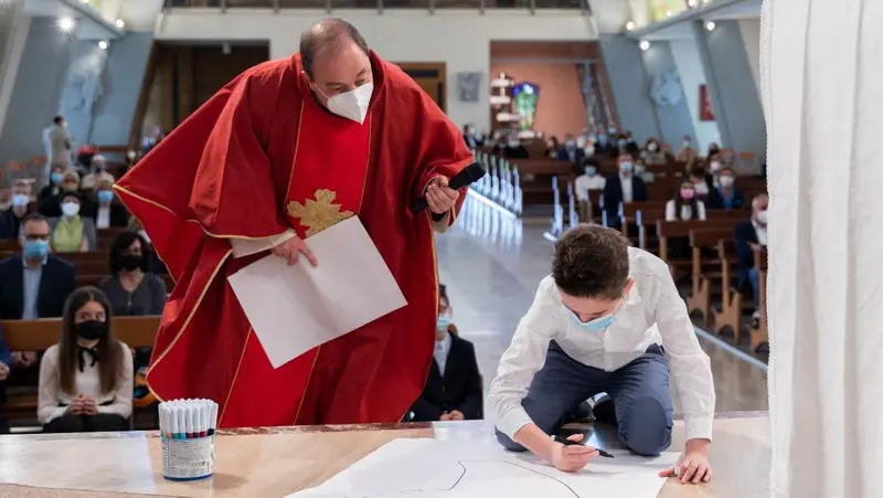 Pietro mentre realizza un disegno durante la cresima - © www.giornaledibrescia.it