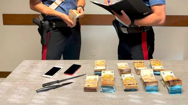 I carabinieri con i contanti e le armi sotto sequestro