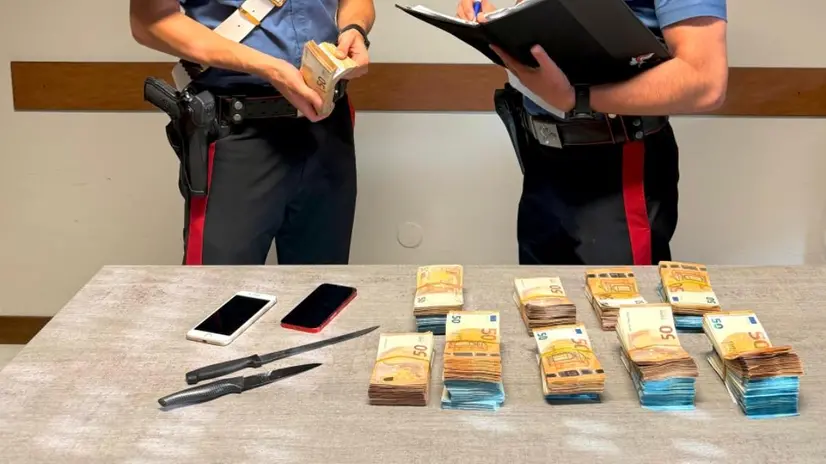 I carabinieri con i contanti e le armi sotto sequestro