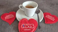 Col caffè il «gadget» rosso con l'invito a donare © www.giornaledibrescia.it