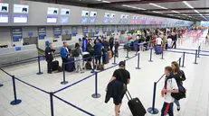 Passeggeri in coda al check-in in un aeroporto